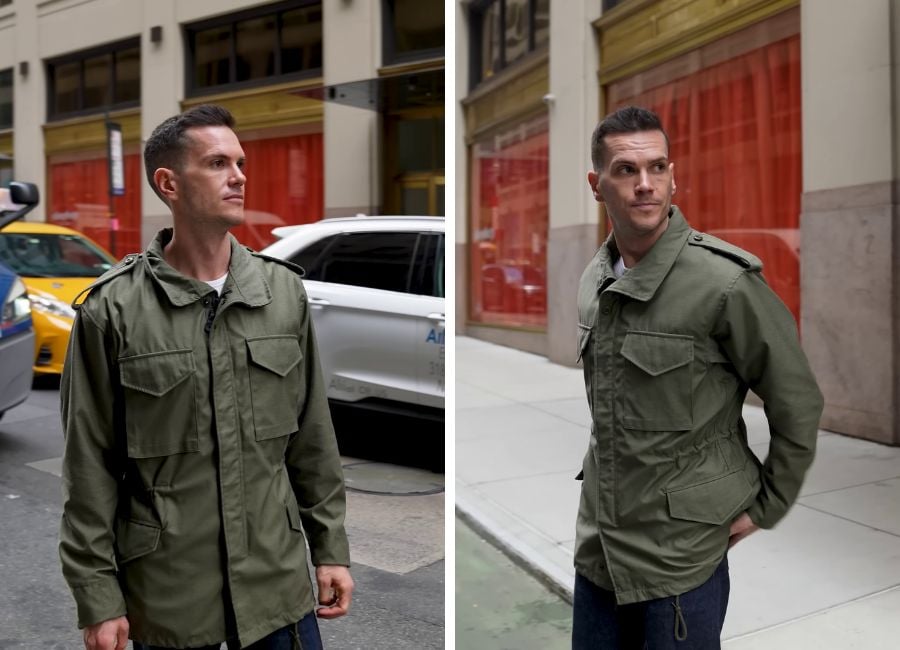 A man standing on a street wearing an army green M-65 jacket