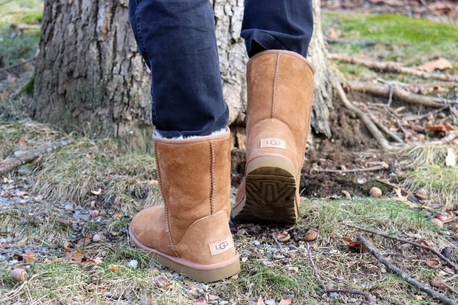 The back of tan suede UGG boots with a visible UGG logo on the heel