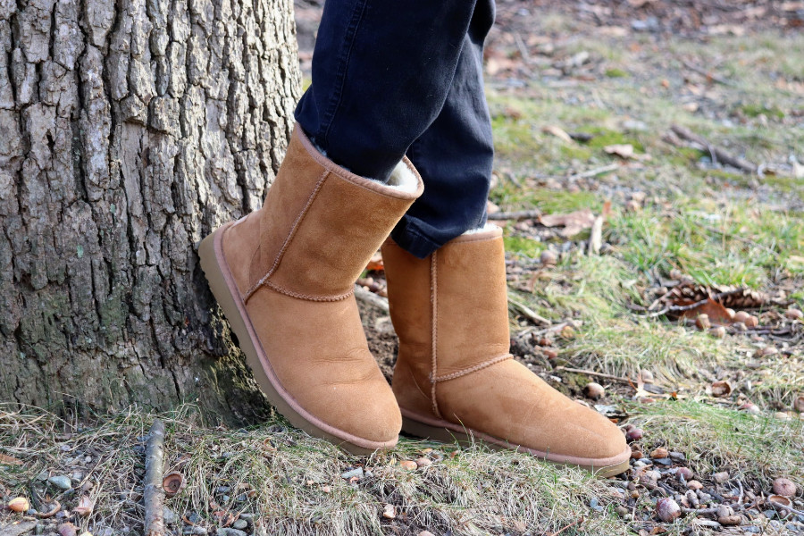 Ugg boots against a tree, black denim