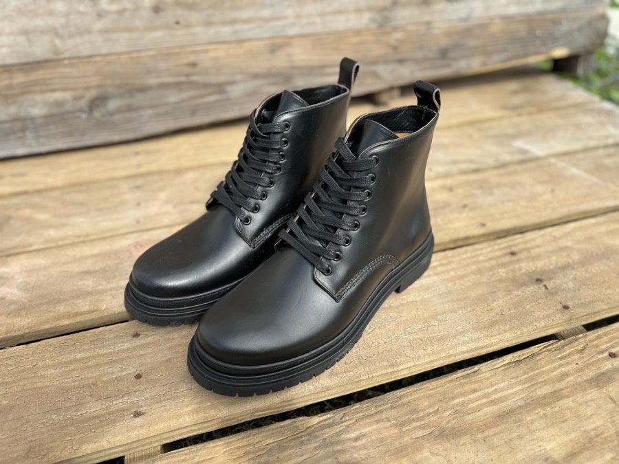 Black Horween leather Goral Sharman boots on wood pallet