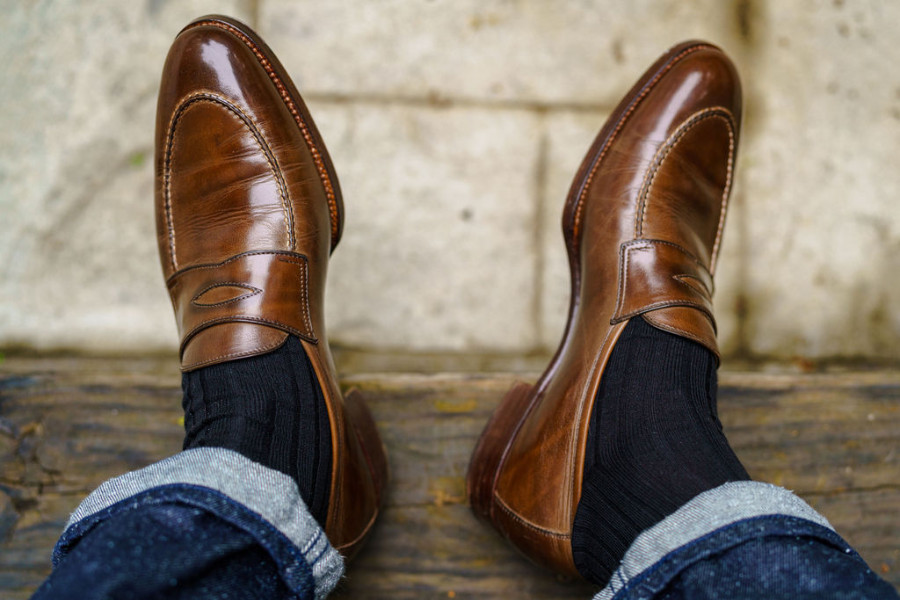 brown loafers, black socks, and denim