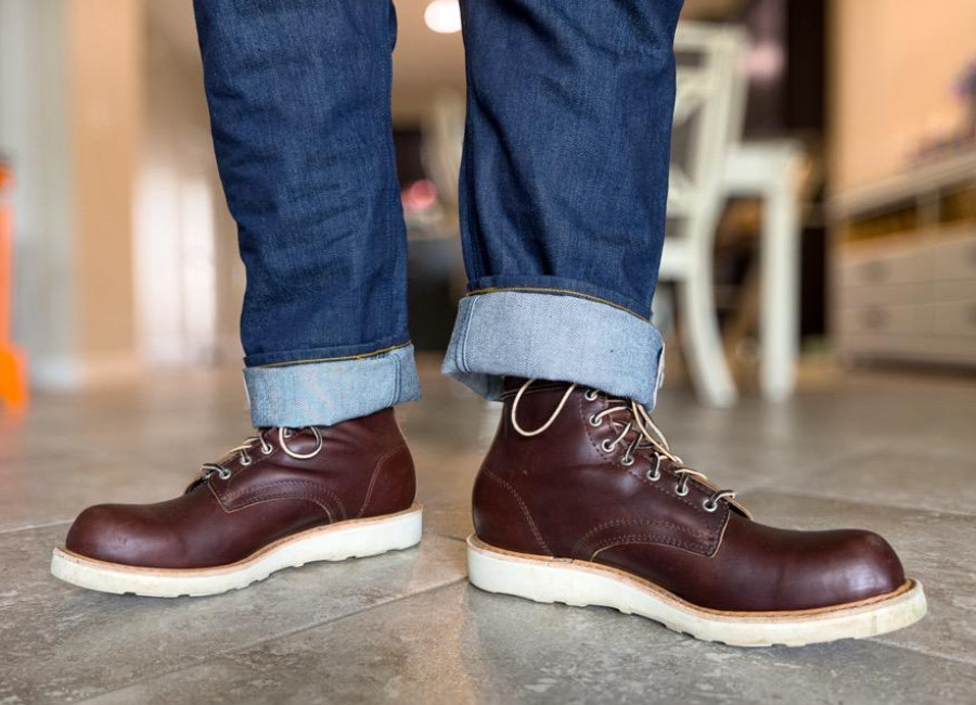 A man standing in White's Springdale, feet akimbo, highlighting the white wedge sole and hot stuffed leather