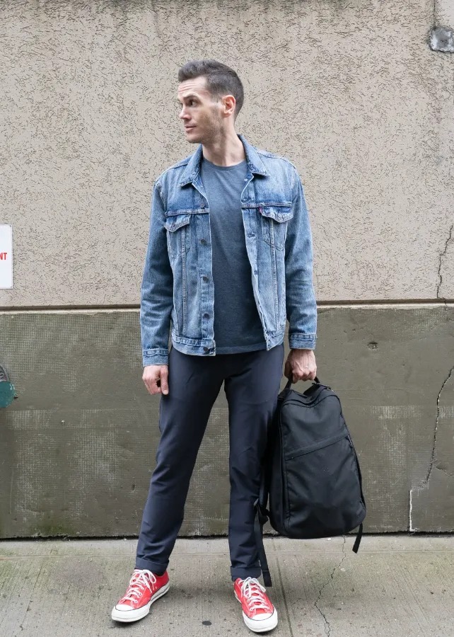 Nick in denim shirt holding goruck backpack