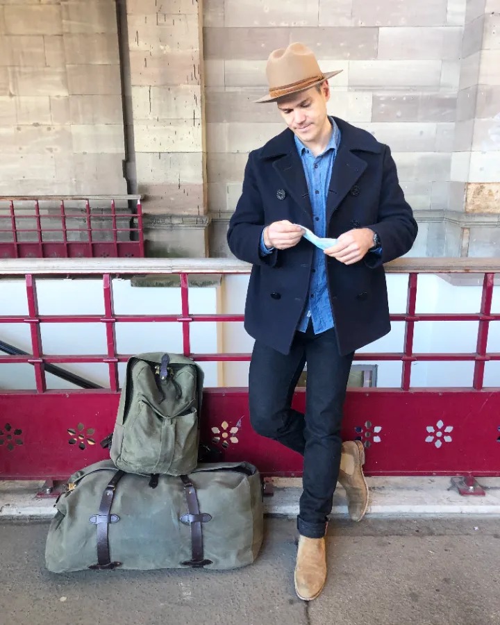 nick in the usn pea coat while traveling with a bunch of bags