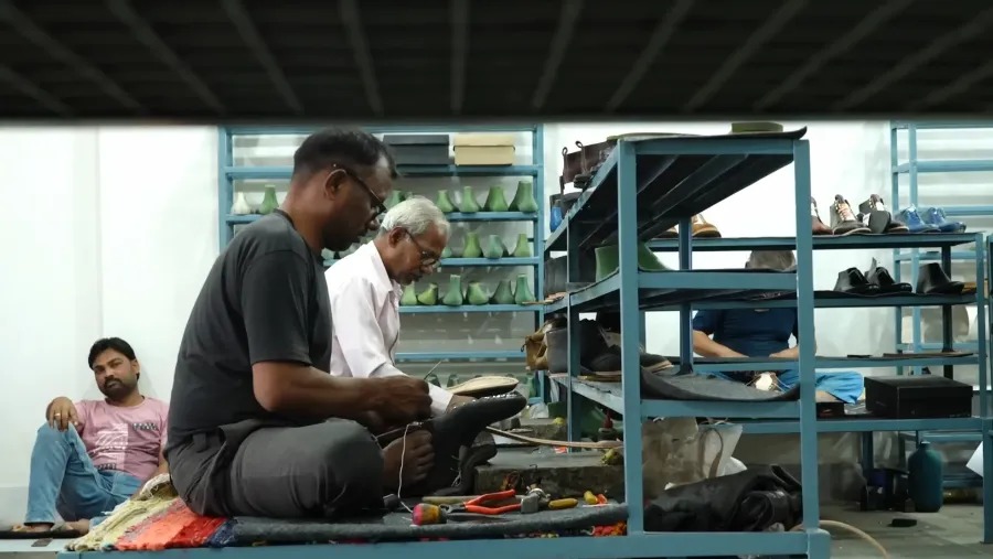 Worker holding boot with feet blkbrd