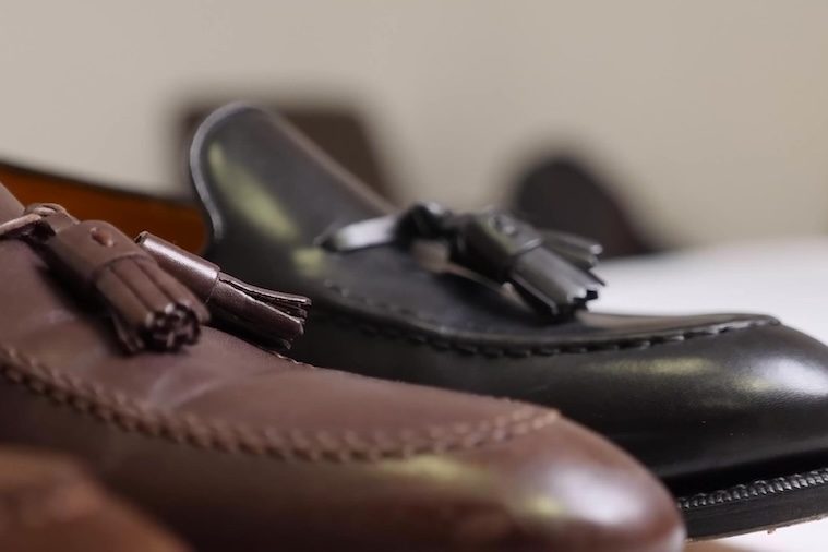 Closeup of brown and black tassel loafers